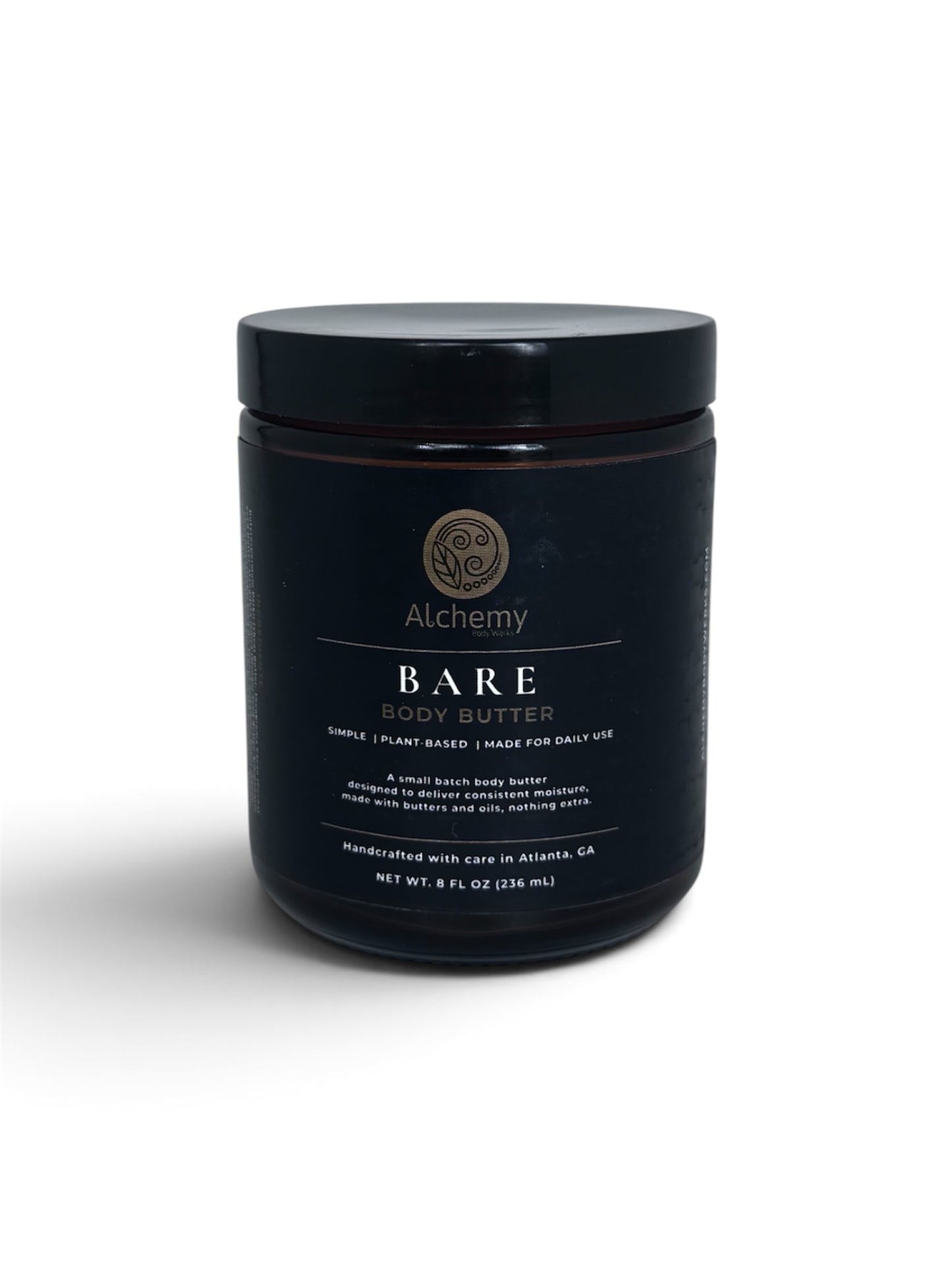 An amber jar with a black lid and black label of Alchemy Body Werks Bare Body Butter on a white background with a soft shadow.