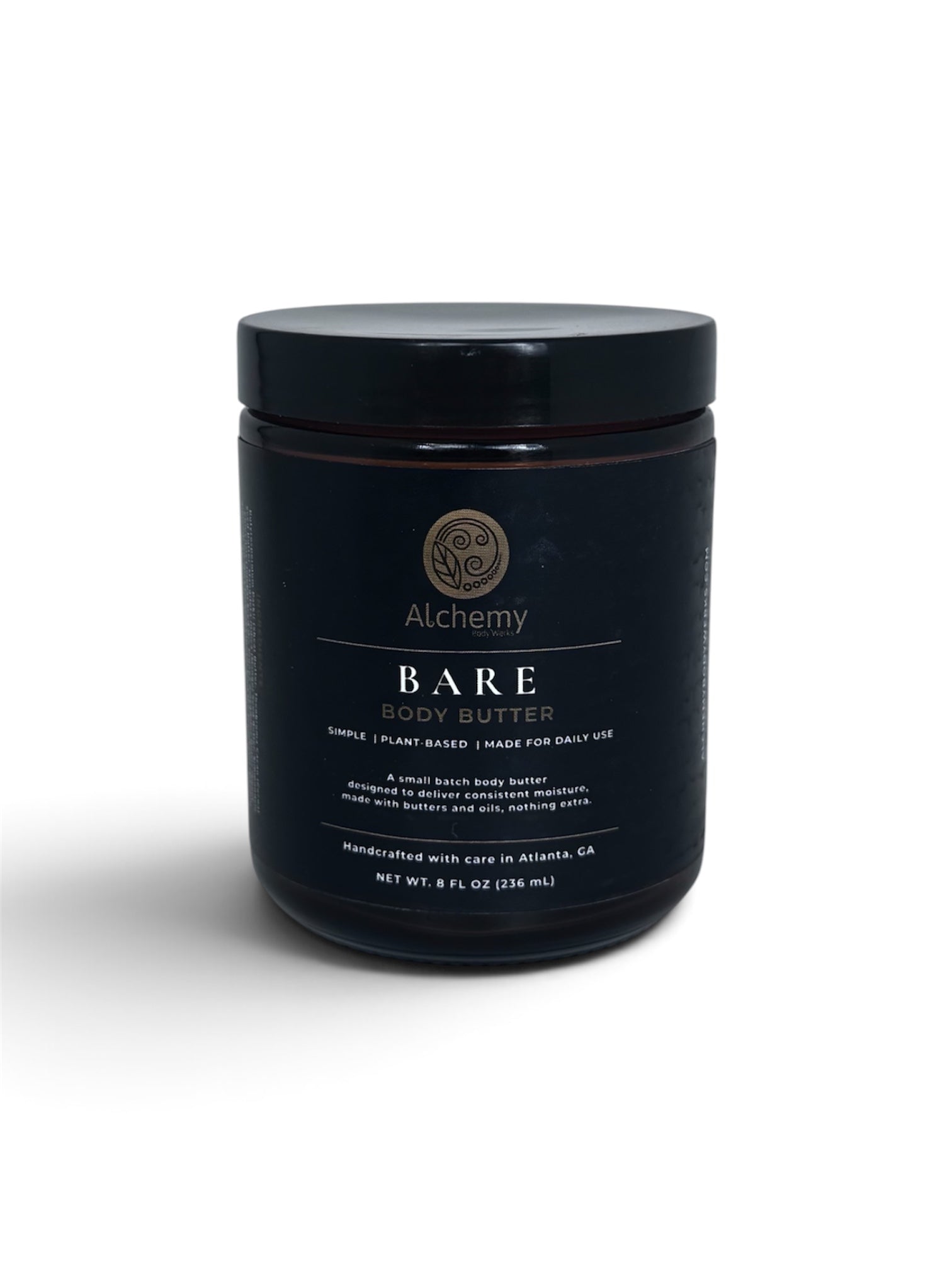 An amber jar with a black lid and black label of Alchemy Body Werks Bare Body Butter on a white background with a soft shadow.