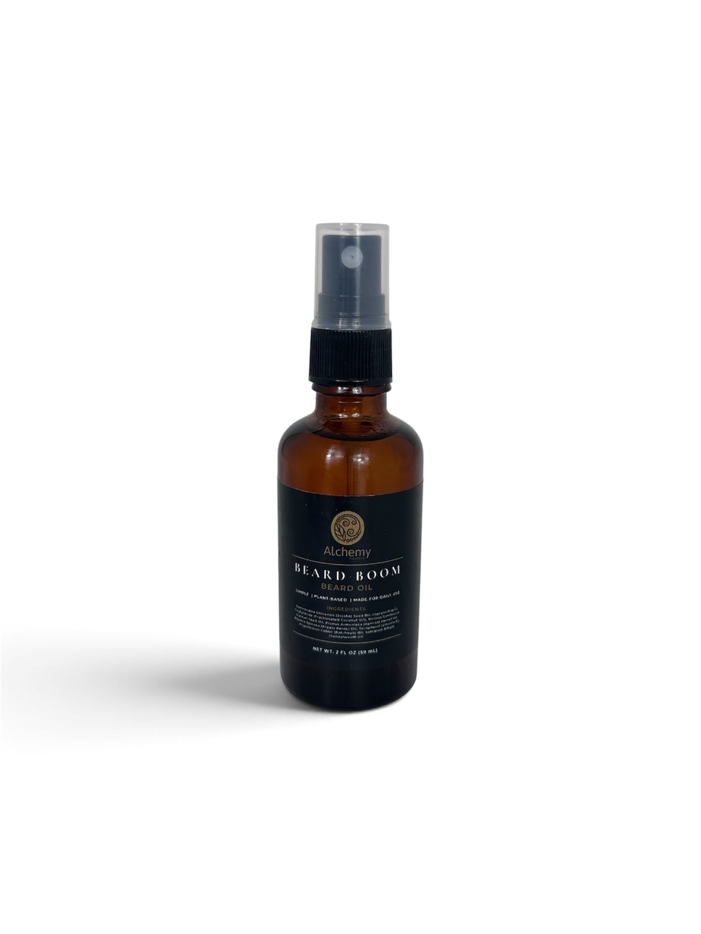 An amber glass bottle spray bottle with a black spray top and a black label of Alchemy Body Werks Beard Boom Beard Oil on a soft white background.