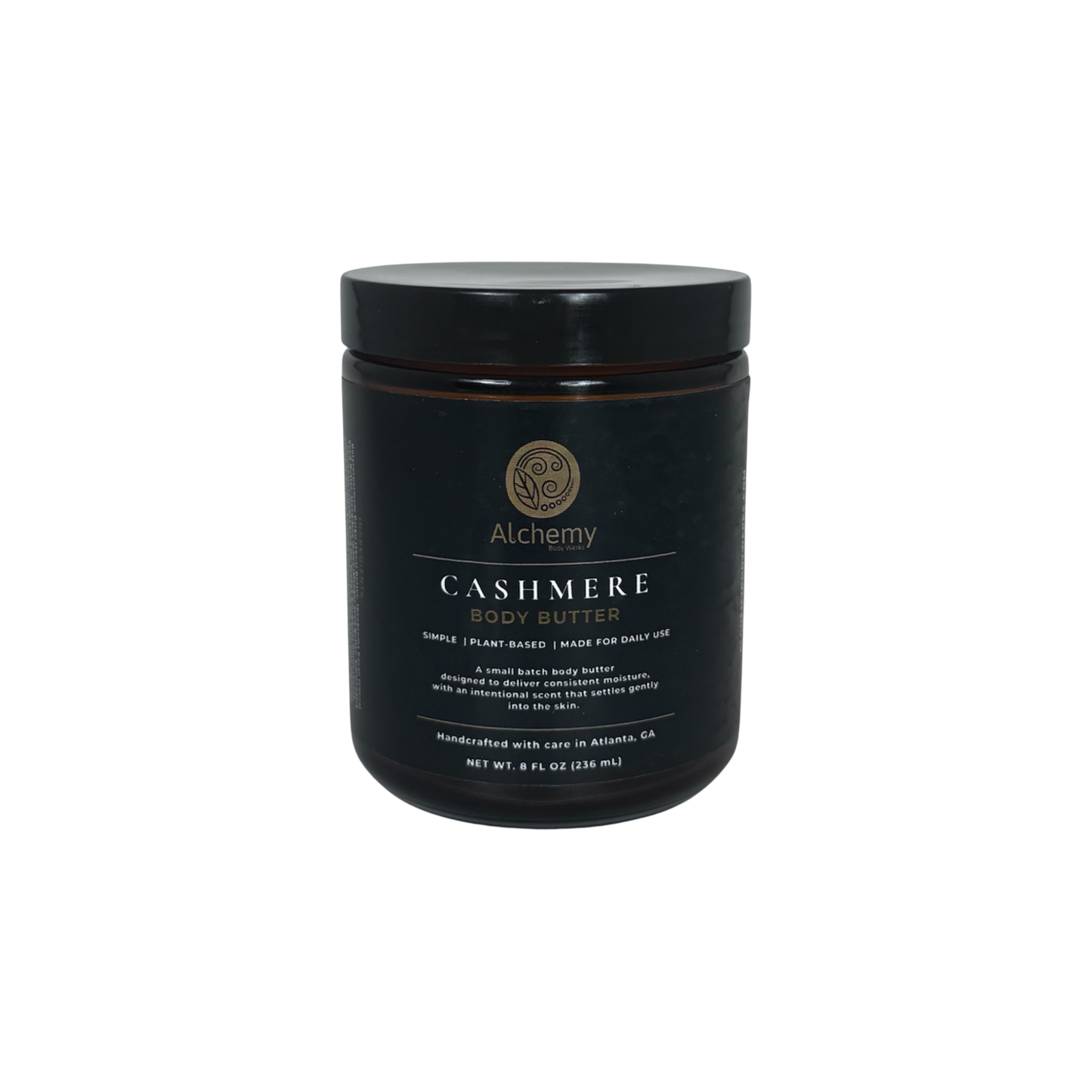 A amber jar with black lid and black label of Alchemy Cashmere Body Butters on a white background.