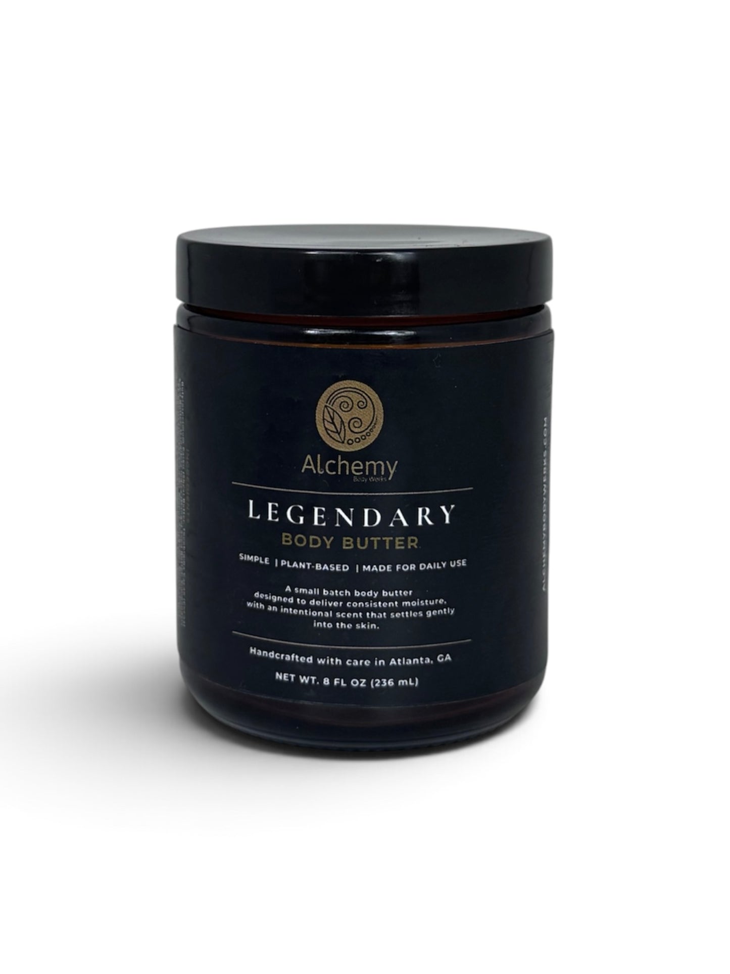 An amber jar with black lid and black label of Alchemy Body Werks Legendary Body Butter on a white background with a soft shadow.