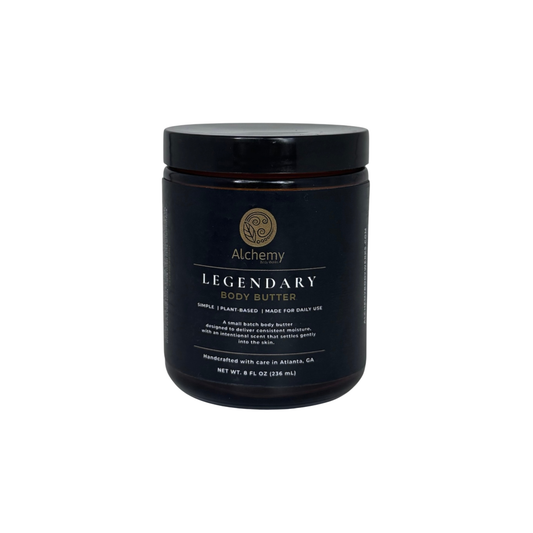 An amber jar with black lid and black label of Alchemy Body Werks Legendary Body Butter on a white background.