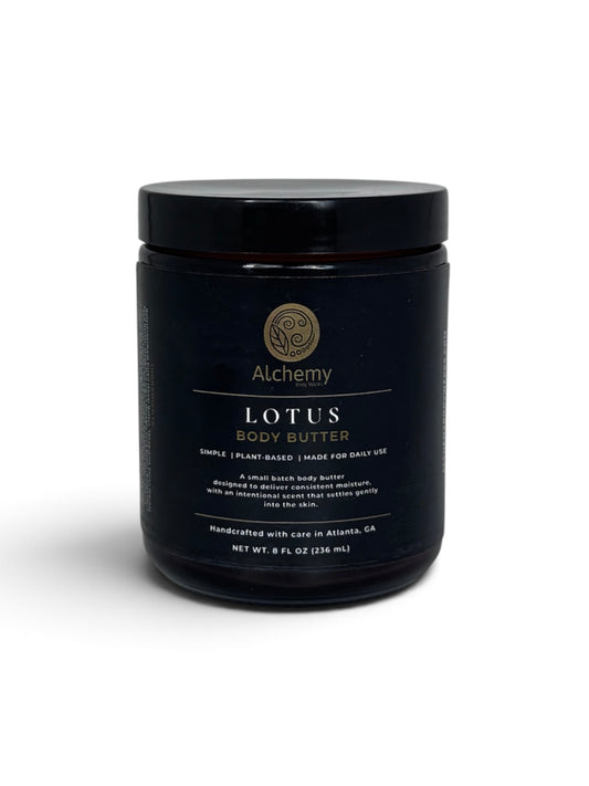 An amber jar with black lid and black label of Alchemy Body Werks Lotus Body Butter on a white background with a soft shadow.