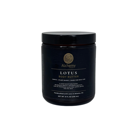 An amber jar with black lid and black label of Alchemy Body Werks Lotus Body Butter on a white background.