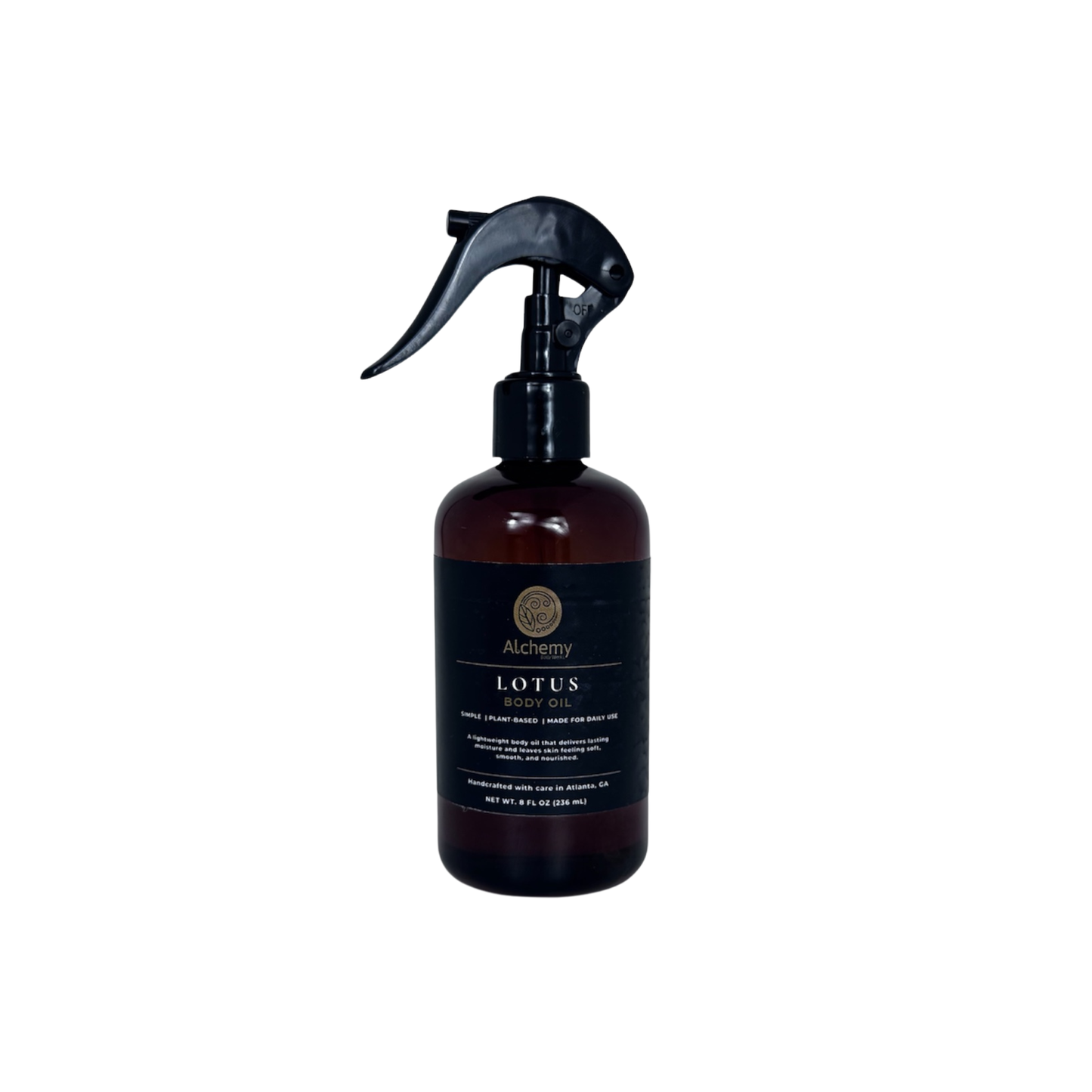 An amber spray bottle with a black trigger sprayer and a black label of Alchemy Body Werks Lotus Body Oil on a white background.