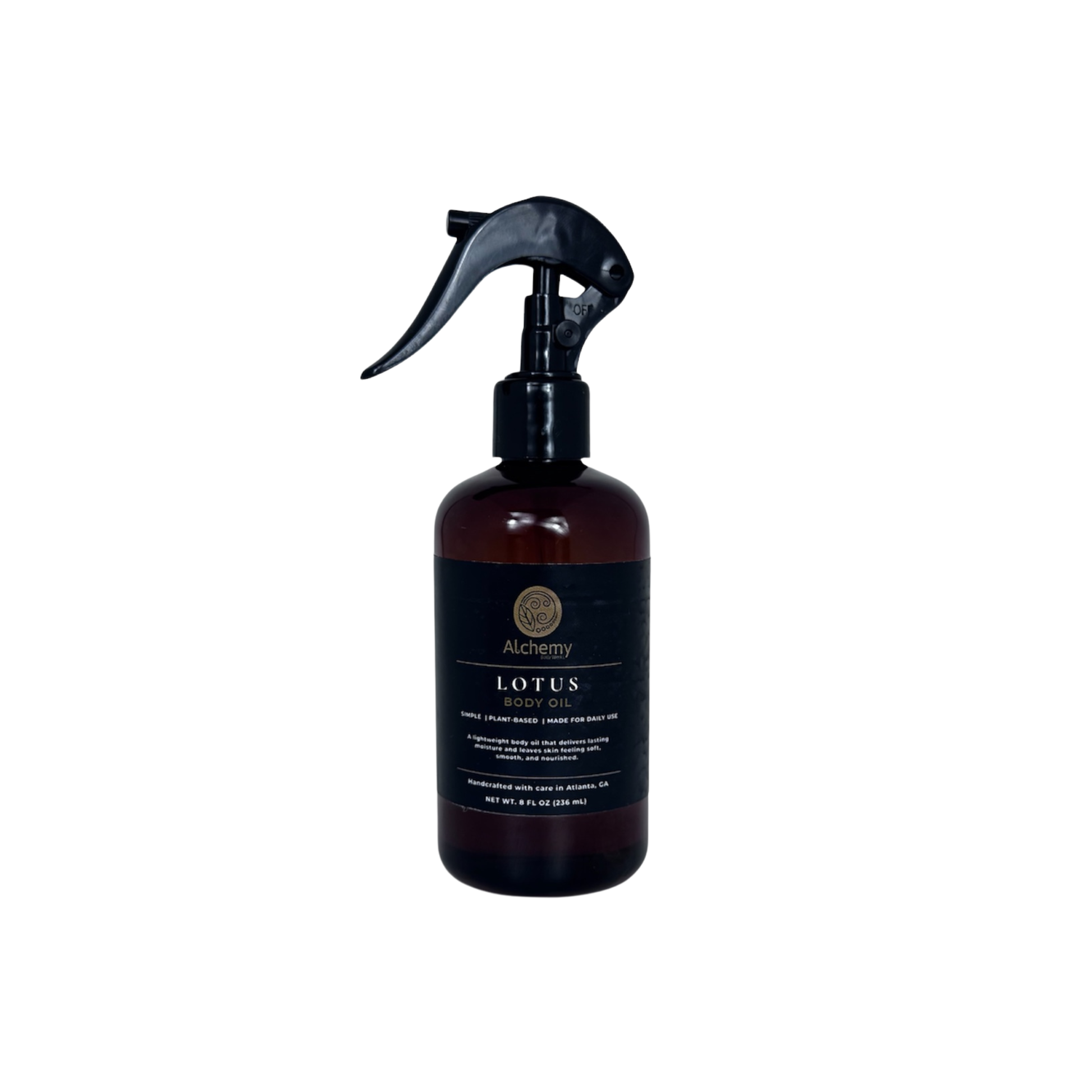 An amber spray bottle with a black trigger sprayer and a black label of Alchemy Body Werks Lotus Body Oil on a white background.
