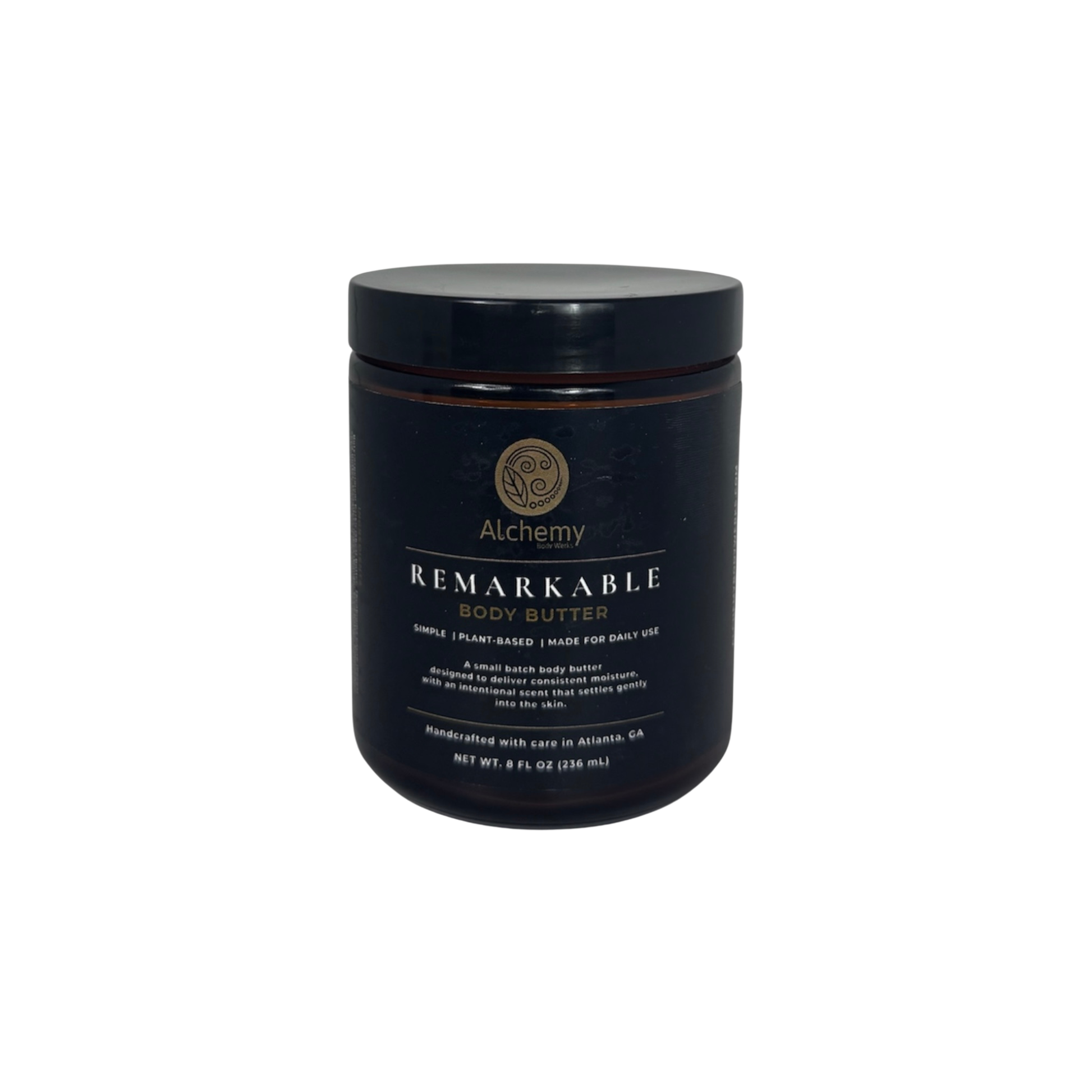 An amber jar with a black lid and black label of Alchemy Body Werks Remarkable Body Butter on a white background.